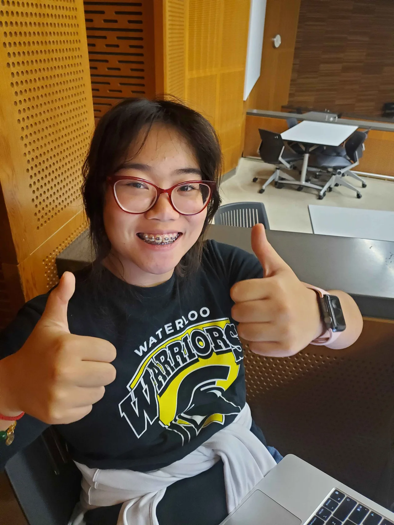 Team member giving two thumbs up at a table