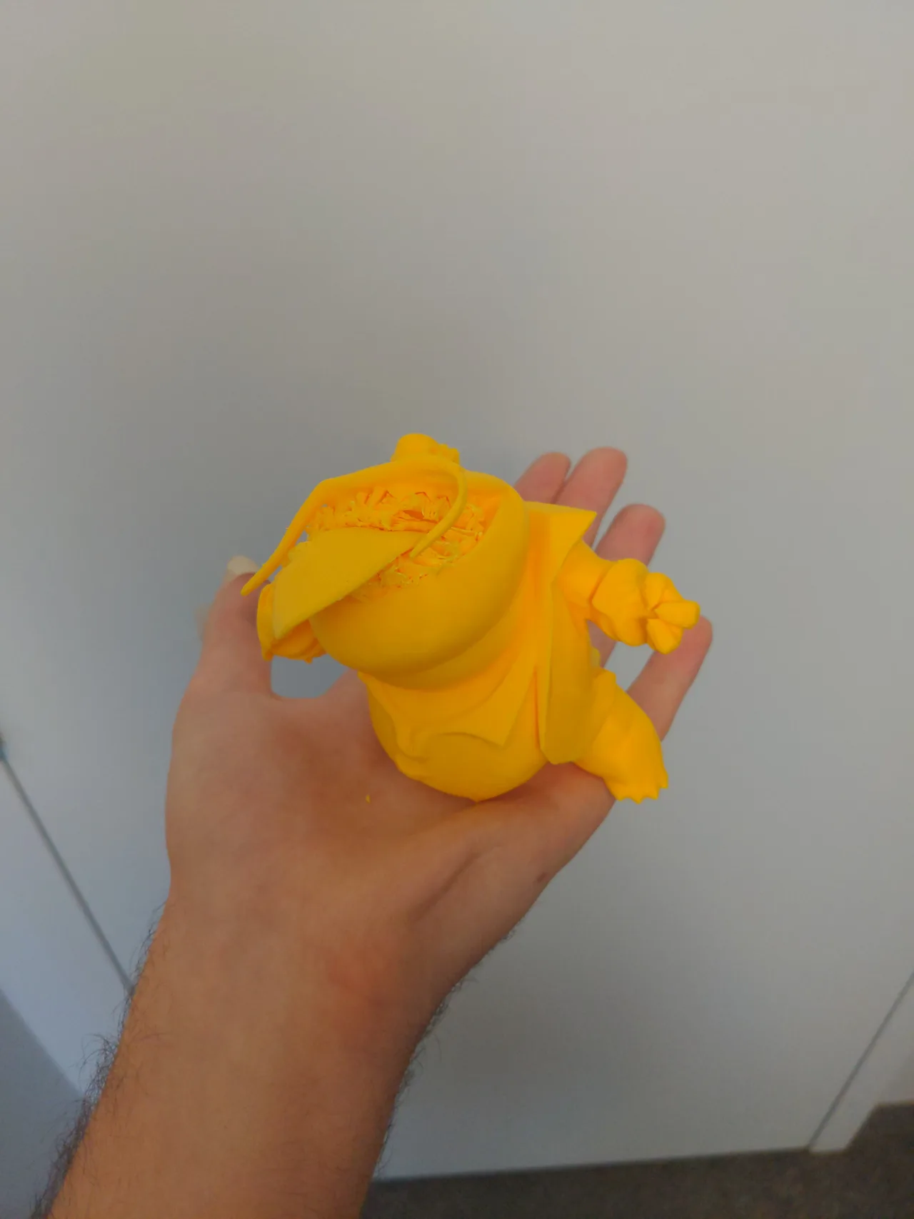 A yellow Tahm Kench print held in one hand, with an incomplete upper section
