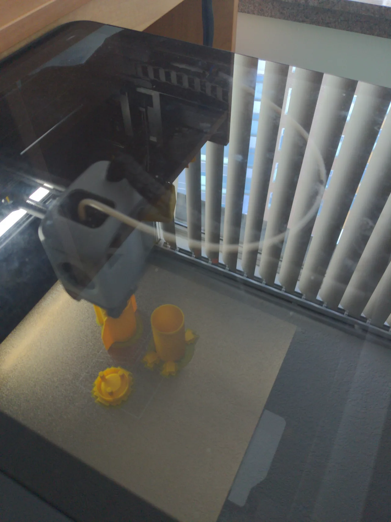 Yellow character parts being printed on the build plate