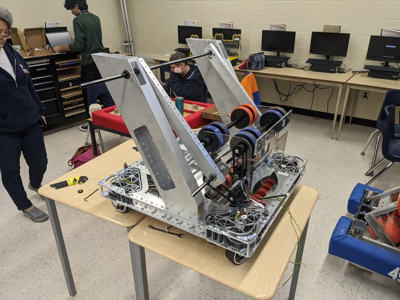 A wider workshop view of the competition robot under construction on a table