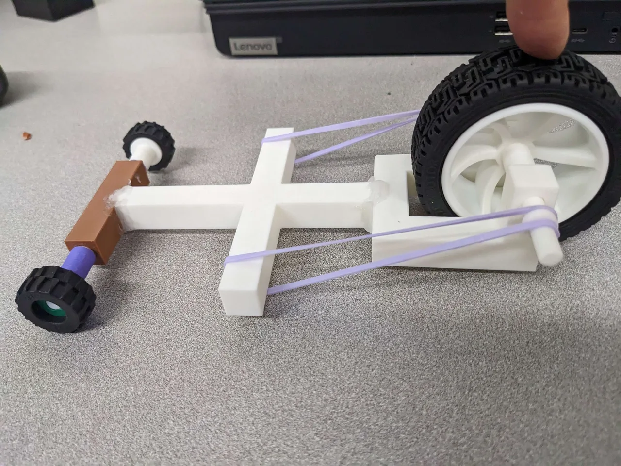 The printed vehicle with purple rubber bands fitted along both sides of the frame