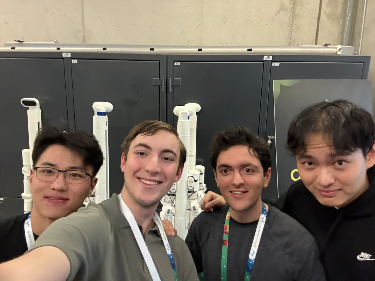 The four-person project team together in front of the robots at Hack the North