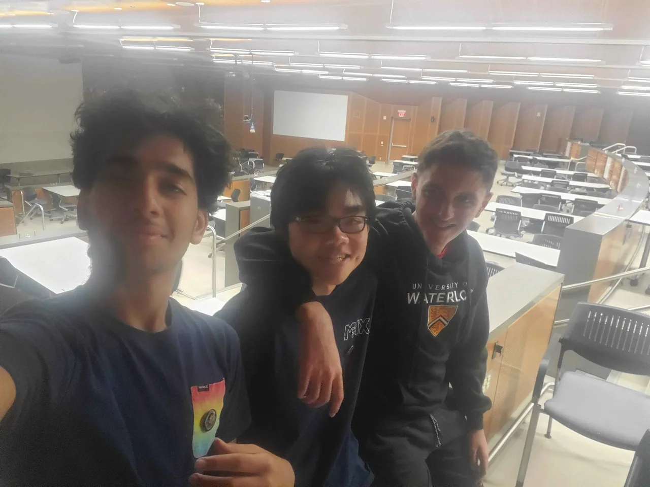 Three MyFarm teammates taking a selfie in an auditorium