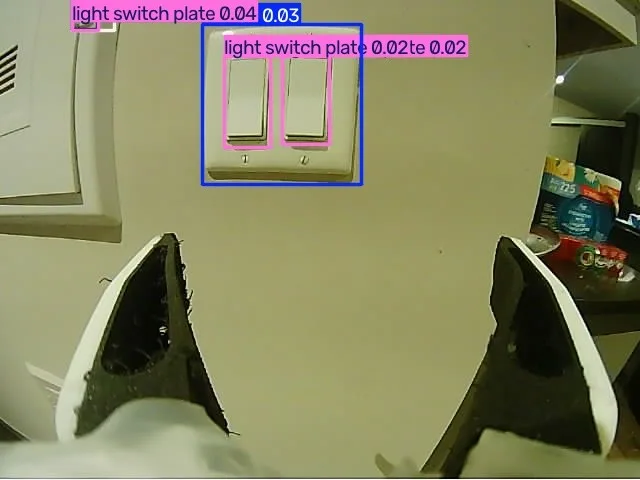 Experimental light-switch detection boxes over the wrist-camera view, with the gripper visible in the foreground